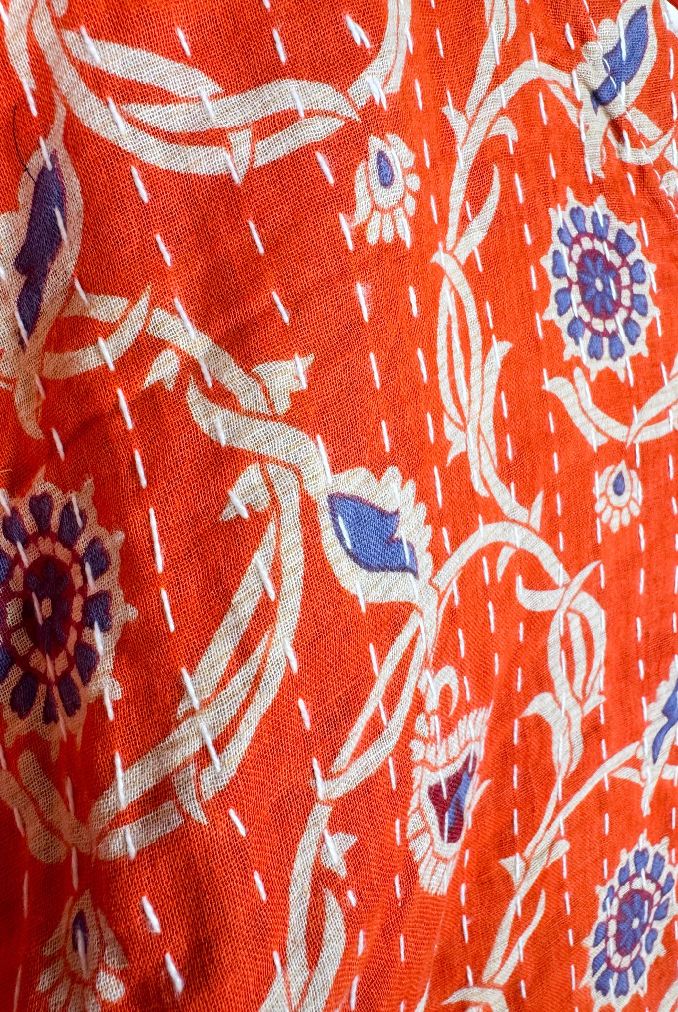 Close-up of a red fabric with white floral patterns - Love Protect Sustain