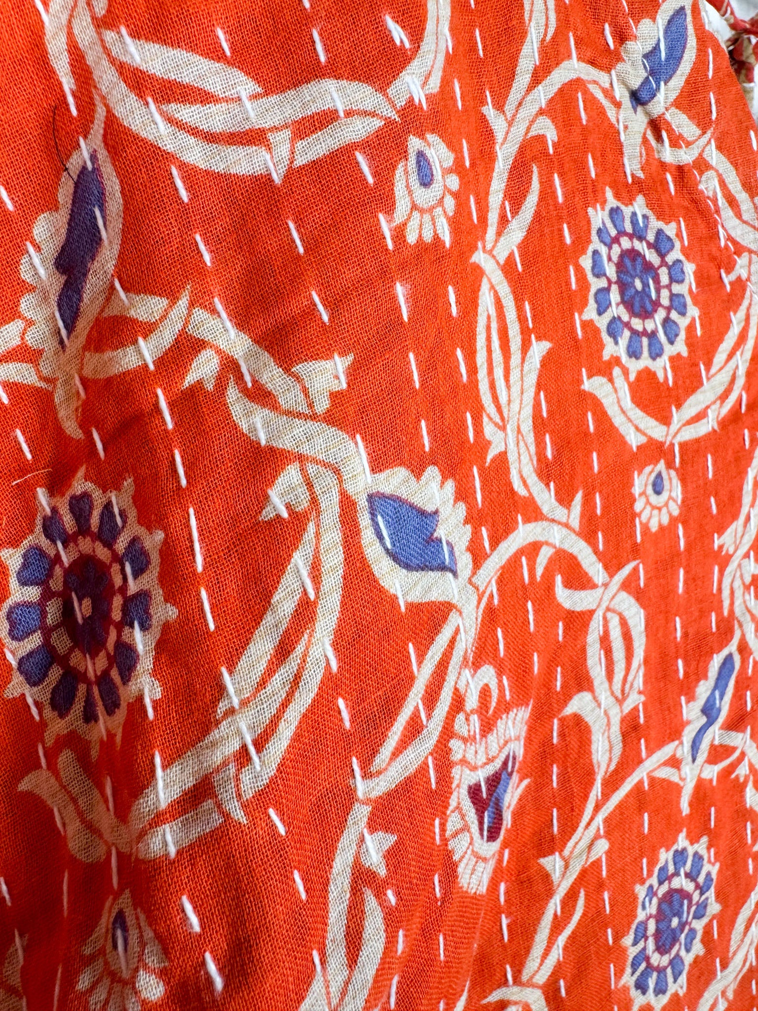 Close-up of a red fabric with white floral patterns - Love Protect Sustain