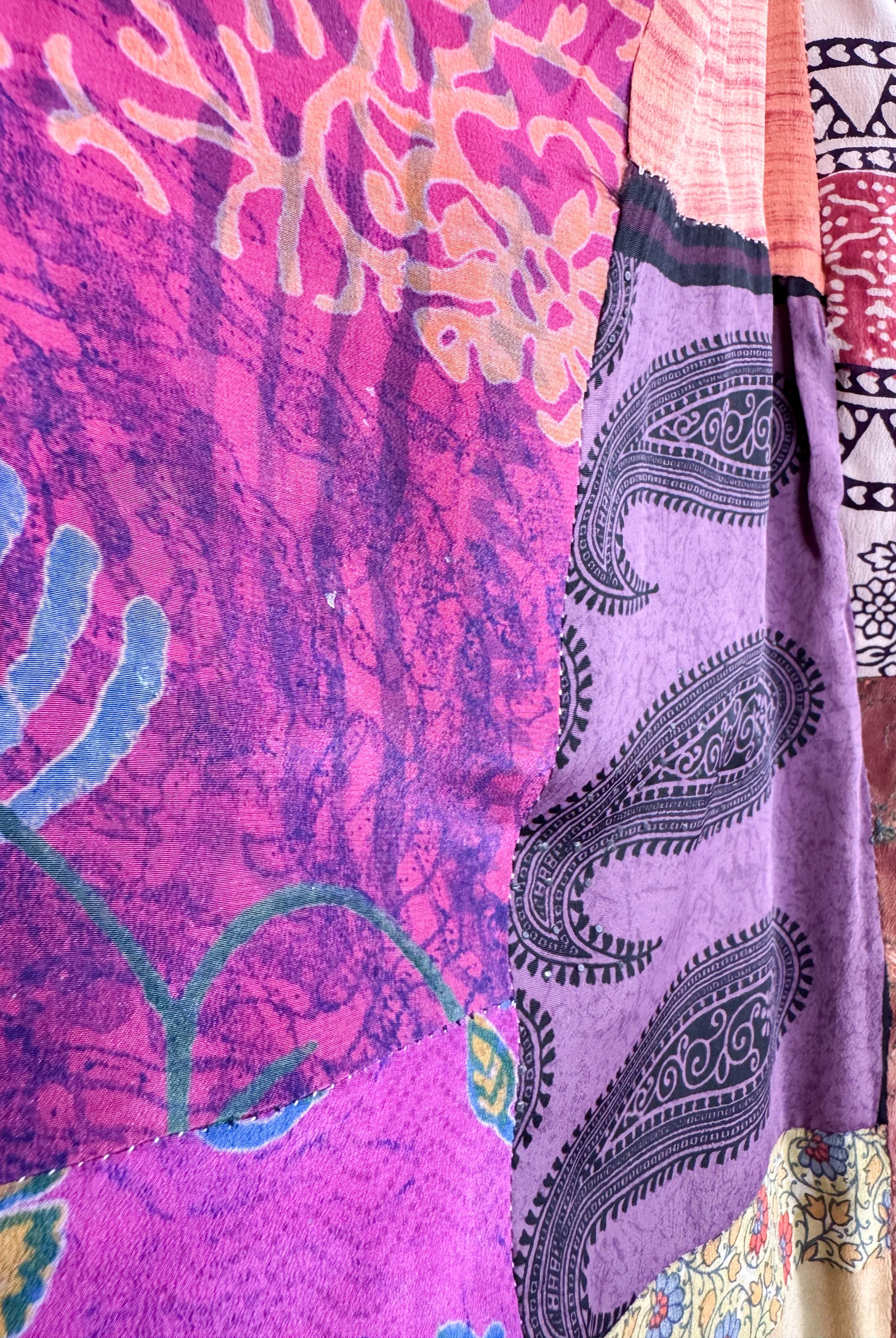 Close-up of colorful fabric with patterns including paisley and abstract designs - Love Protect Sustain