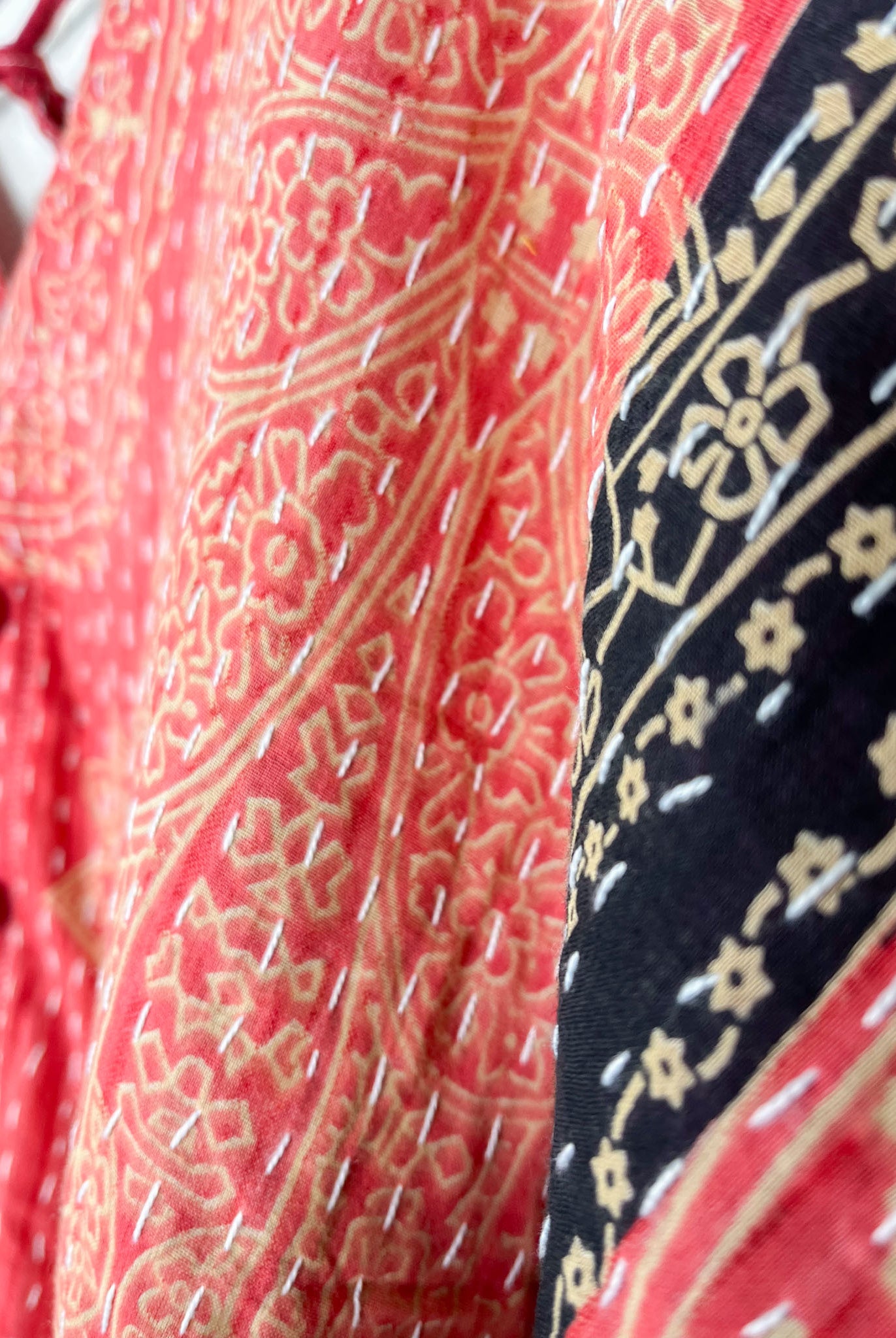 Close-up of patterned fabric with red and black designs - Love Protect Sustain