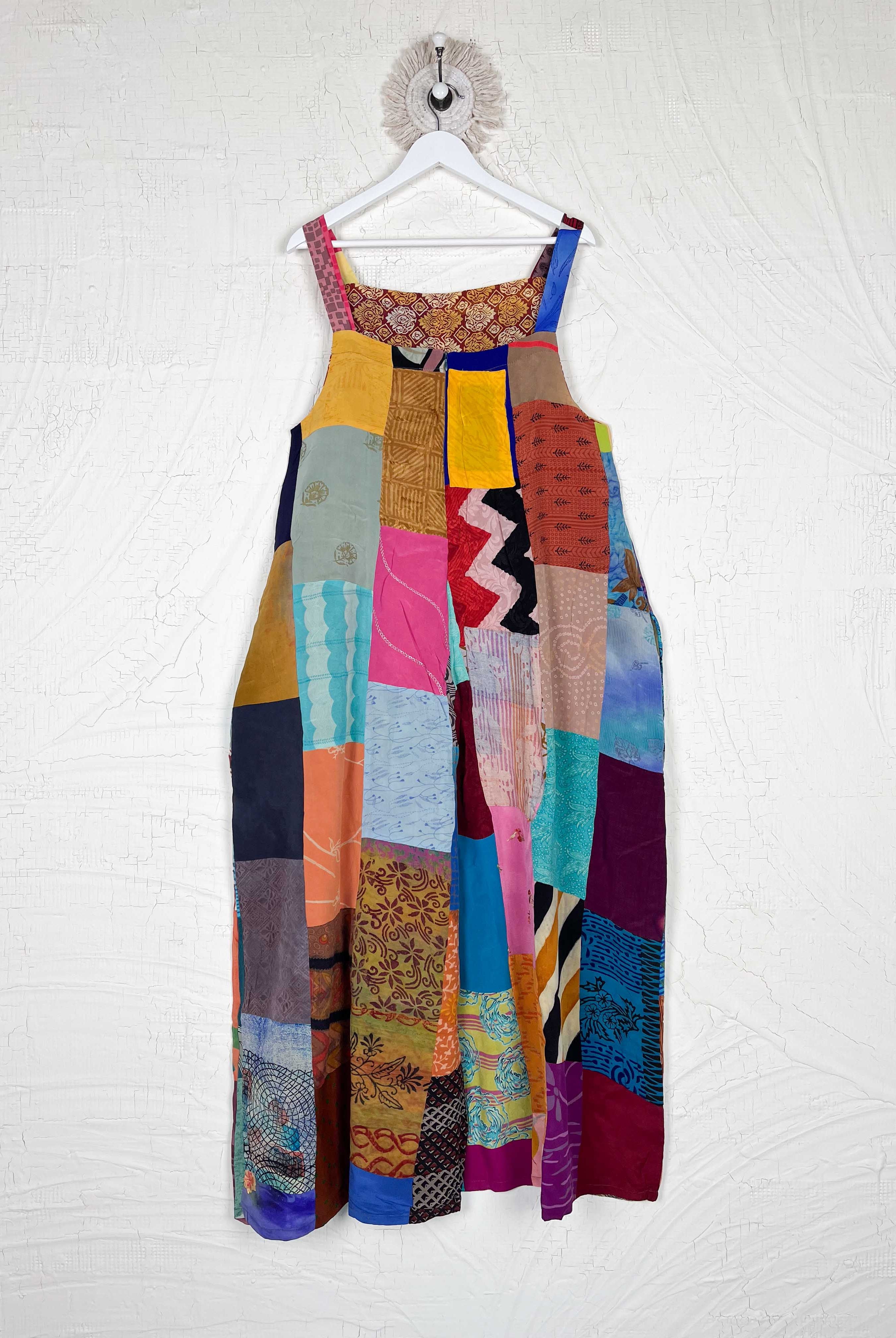 Colorful patchwork dress hanging on a white wall - Love Protect Sustain