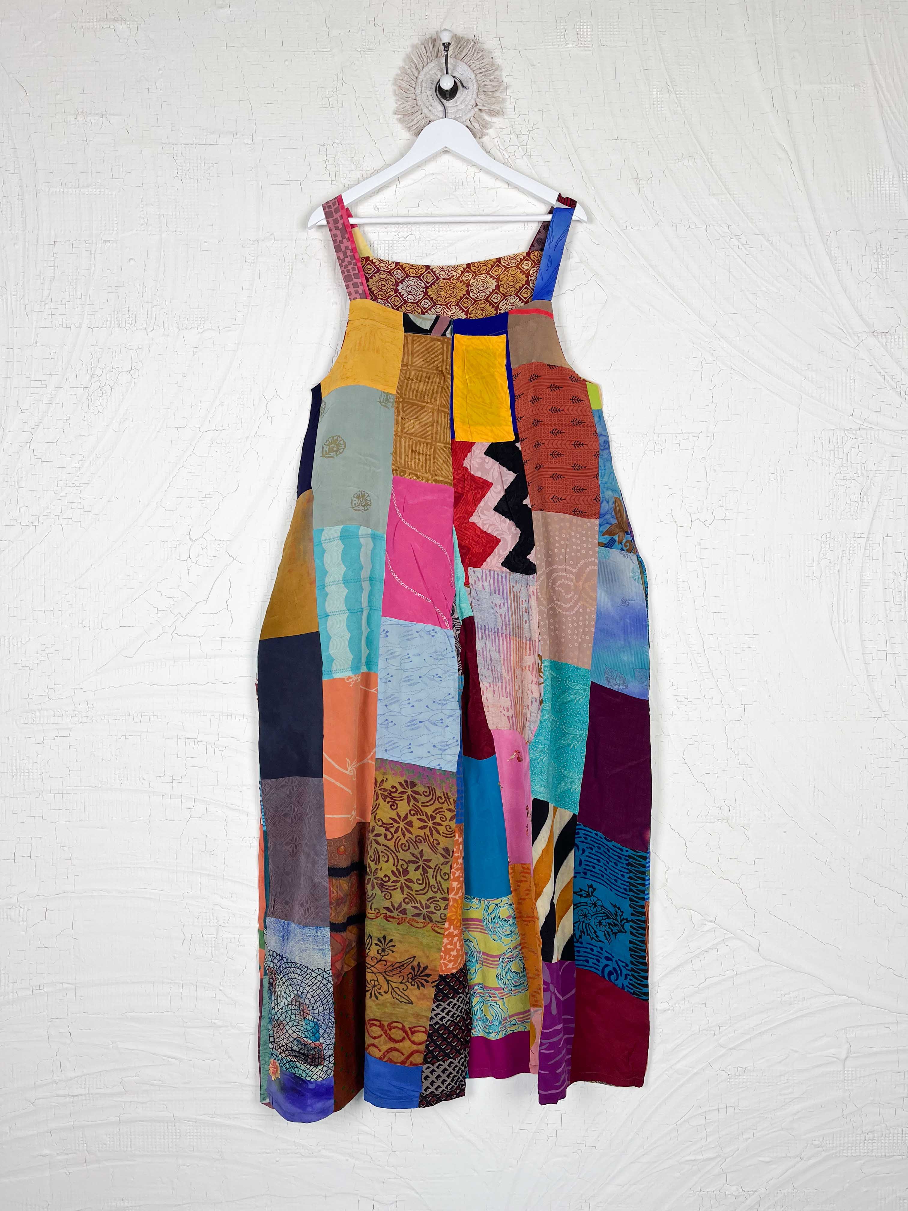 Colorful patchwork dress hanging on a white wall - Love Protect Sustain
