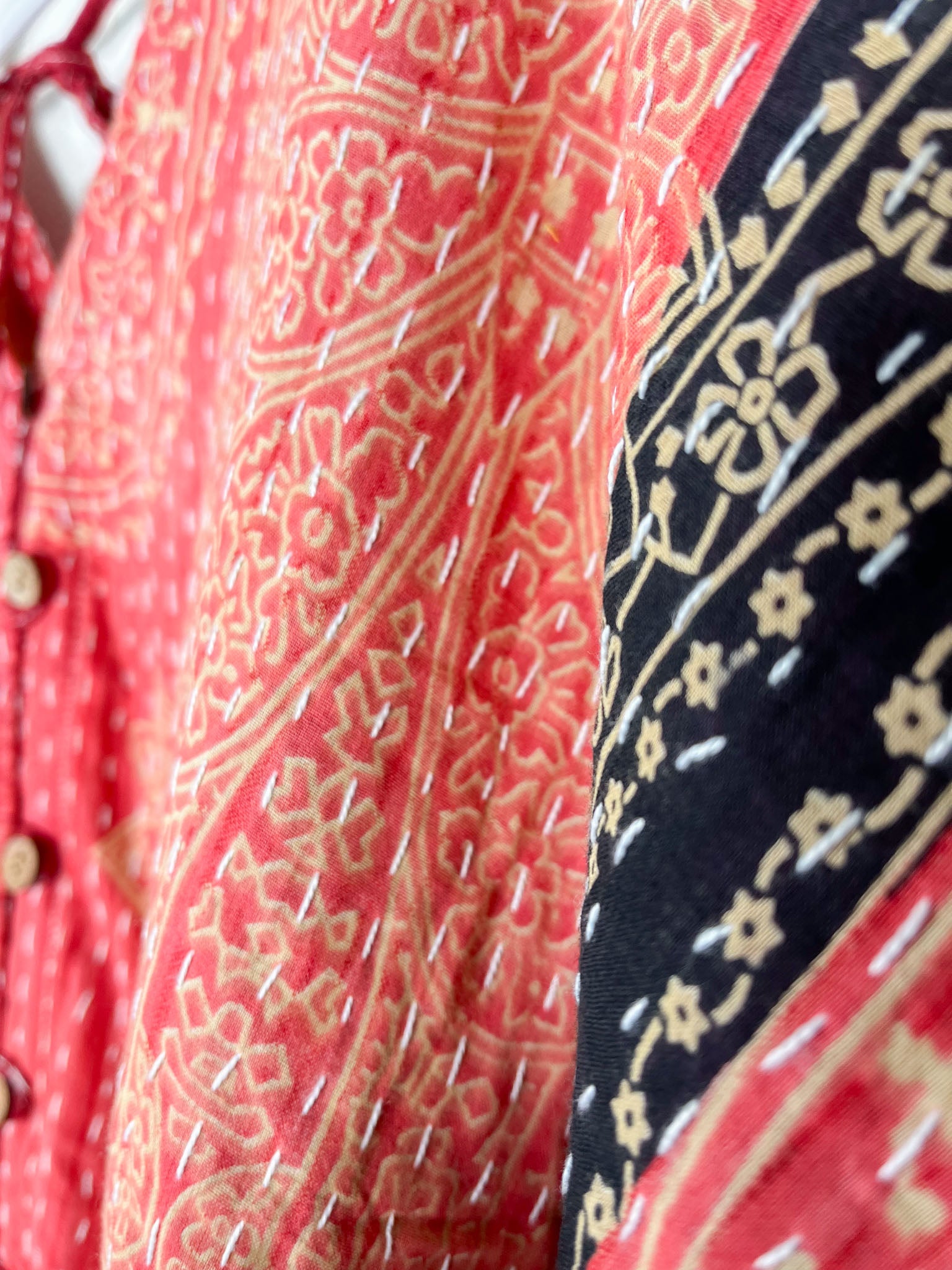 Close-up of patterned fabric with red and black designs - Love Protect Sustain