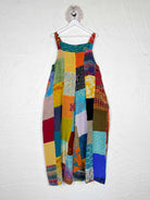 Colorful patchwork dress hanging on a white wall - Love Protect Sustain