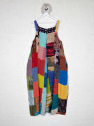 Colorful patchwork dress hanging on a white wall - Love Protect Sustain