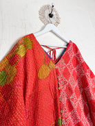Two red patterned tops hanging on a white hanger against a white wall Lover Protect Sustain